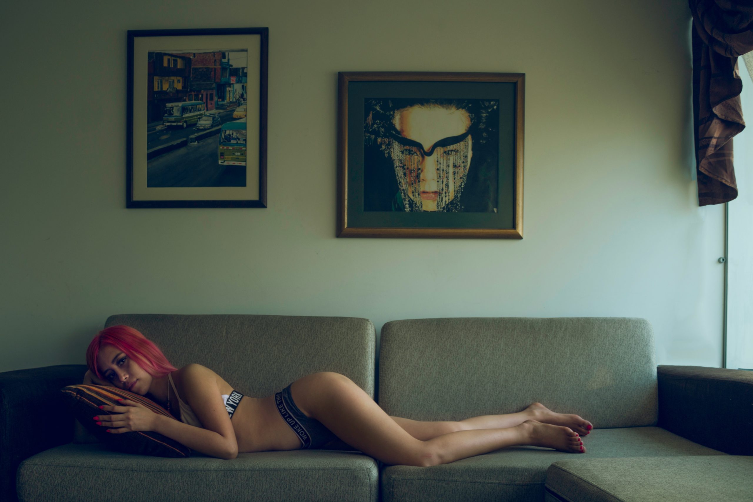 woman in bikini lying on gray corner sofa